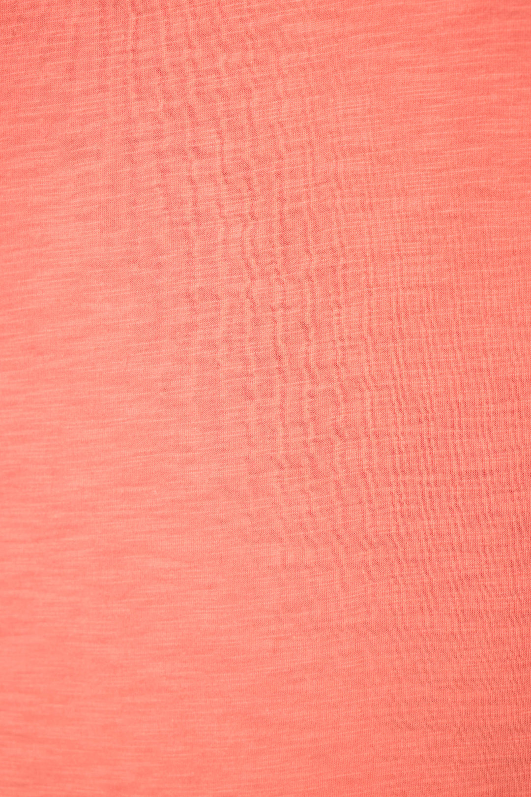 Close-up of coral pink fabric with smooth surface, subtle woven texture, and visible horizontal and vertical thread lines.