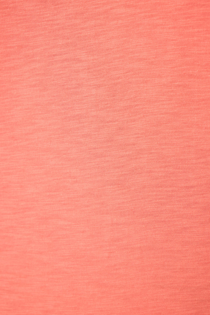 Close-up of coral pink fabric with smooth surface, subtle woven texture, and visible horizontal and vertical thread lines.