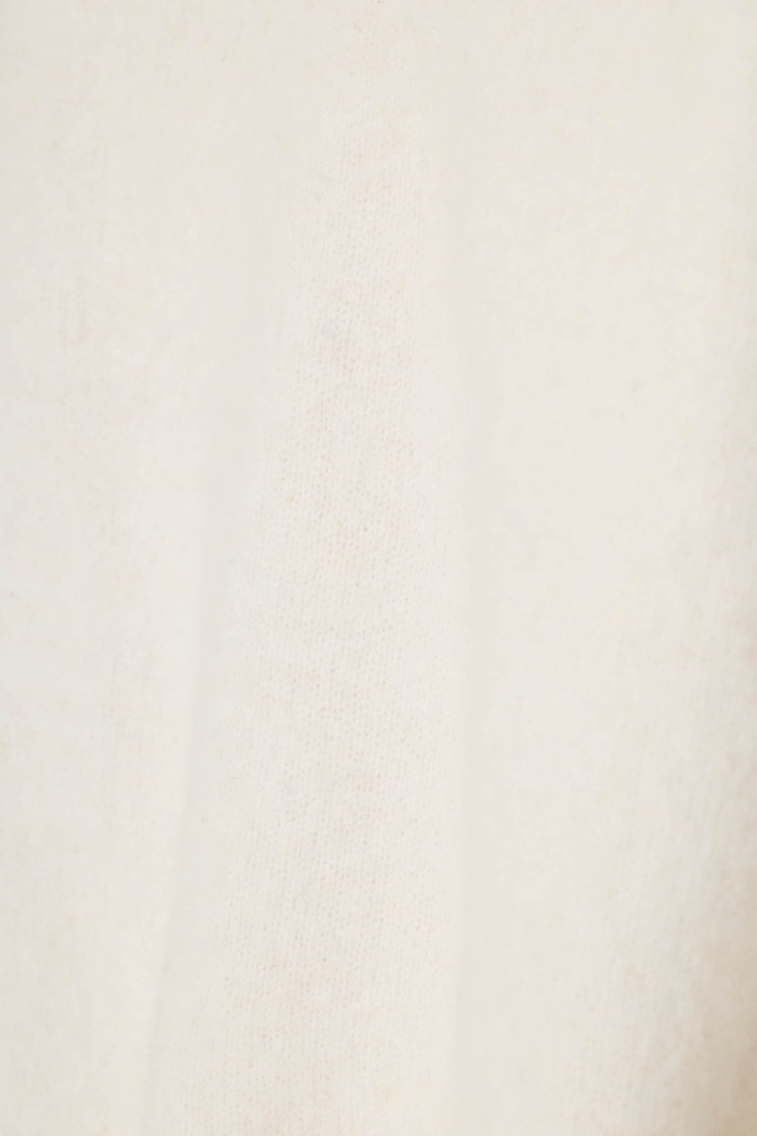 A close-up of a soft, textured off-white fabric with a subtle warm undertone.