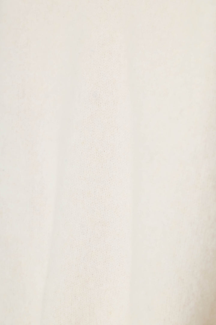 A close-up of a soft, textured off-white fabric with a subtle warm undertone.