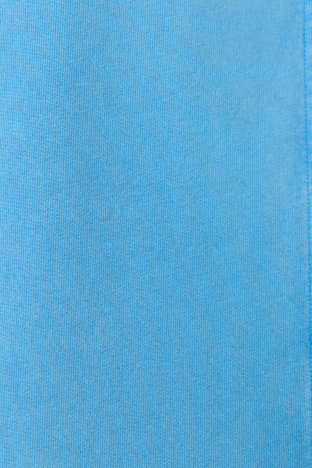 Close-up of the P.J. Salvage Washed Away Marine Blue Shirt Jacket fabric shows a smooth, evenly colored surface with subtle ribbed texture and fine vertical lines, making it ideal for a relaxed, stylish look.