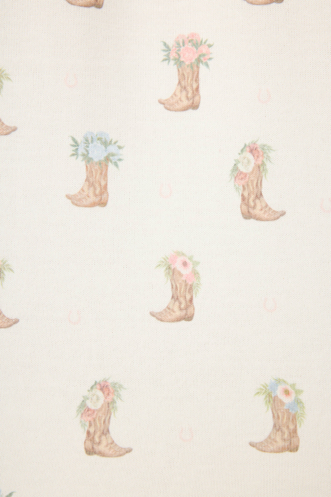 The P.J. Salvage Western Blooms Boot Bouquet Short Sleeve Top features cowboy boots with pastel pink, blue, and white flowers on a light beige background, plus subtle horseshoes—perfect for a peach-hued jersey pajama tee.