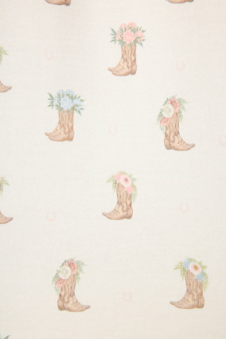 The P.J. Salvage Western Blooms Boot Bouquet Short Sleeve Top features cowboy boots with pastel pink, blue, and white flowers on a light beige background, plus subtle horseshoes—perfect for a peach-hued jersey pajama tee.