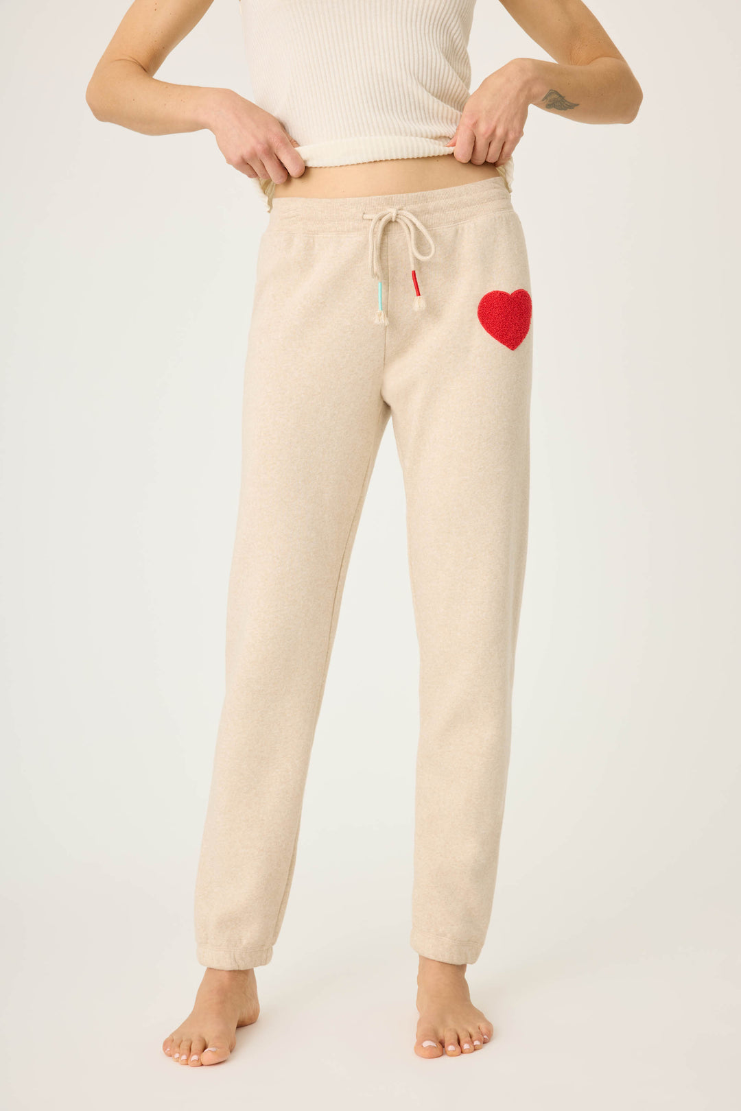 Women's oatmeal jogger pant with red boucle heart applique. Oatmeal cloud terry with tie waist.