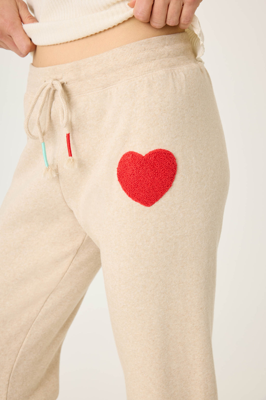 Women's oatmeal jogger pant with red boucle heart applique. Oatmeal cloud terry with tie waist.