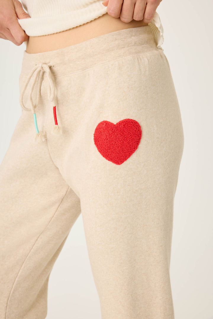 Women's oatmeal jogger pant with red boucle heart applique. Oatmeal cloud terry with tie waist.