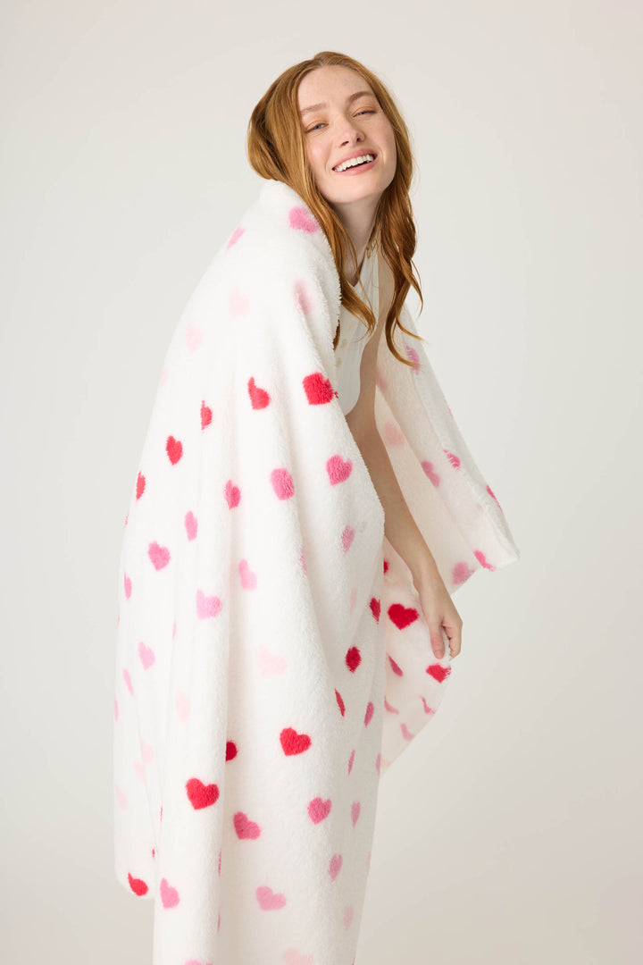 Plush ivory blanket with pink heart pattern.