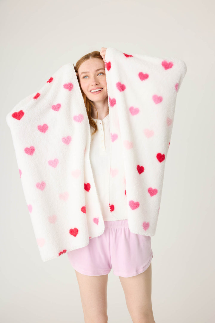 Plush ivory blanket with pink heart pattern.
