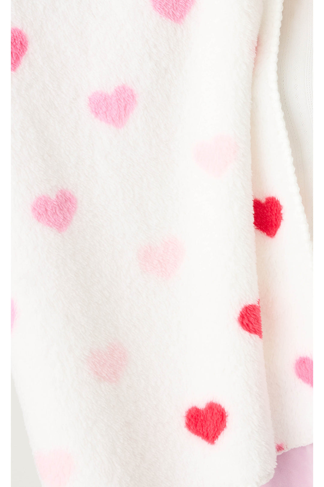 Plush ivory blanket with pink heart pattern.