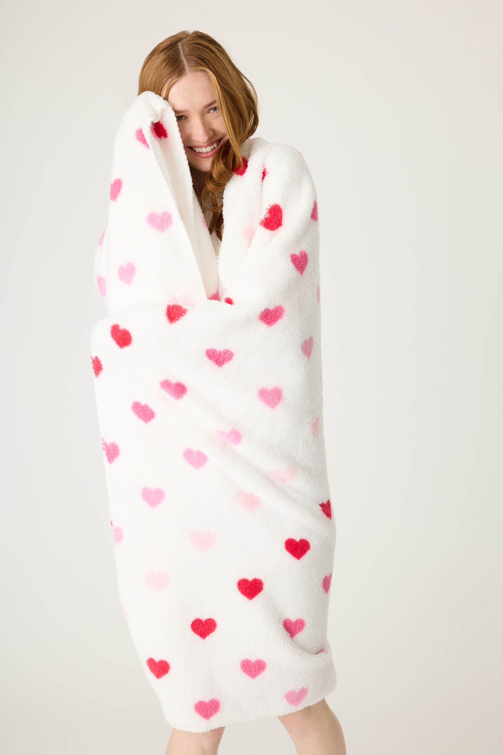 Plush ivory blanket with pink heart pattern.