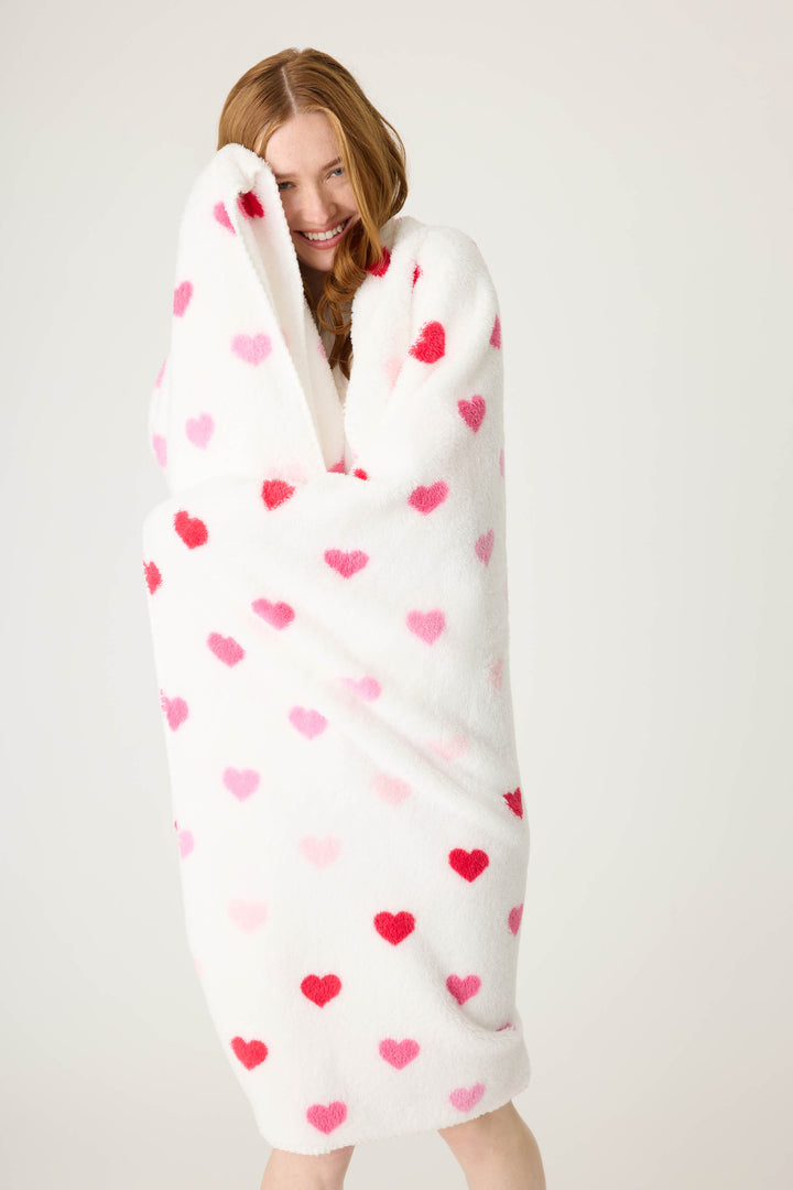 Plush ivory blanket with pink heart pattern.