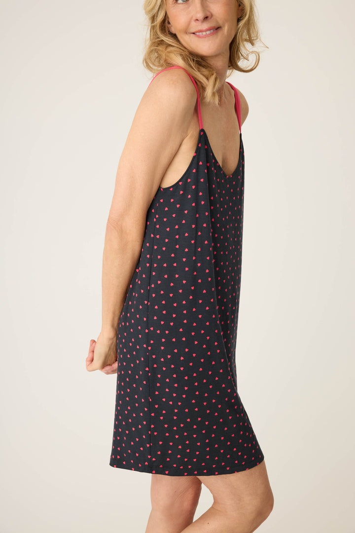 Women's black sleep chemise with shelf bra, adjustable straps and pink heart pattern.
