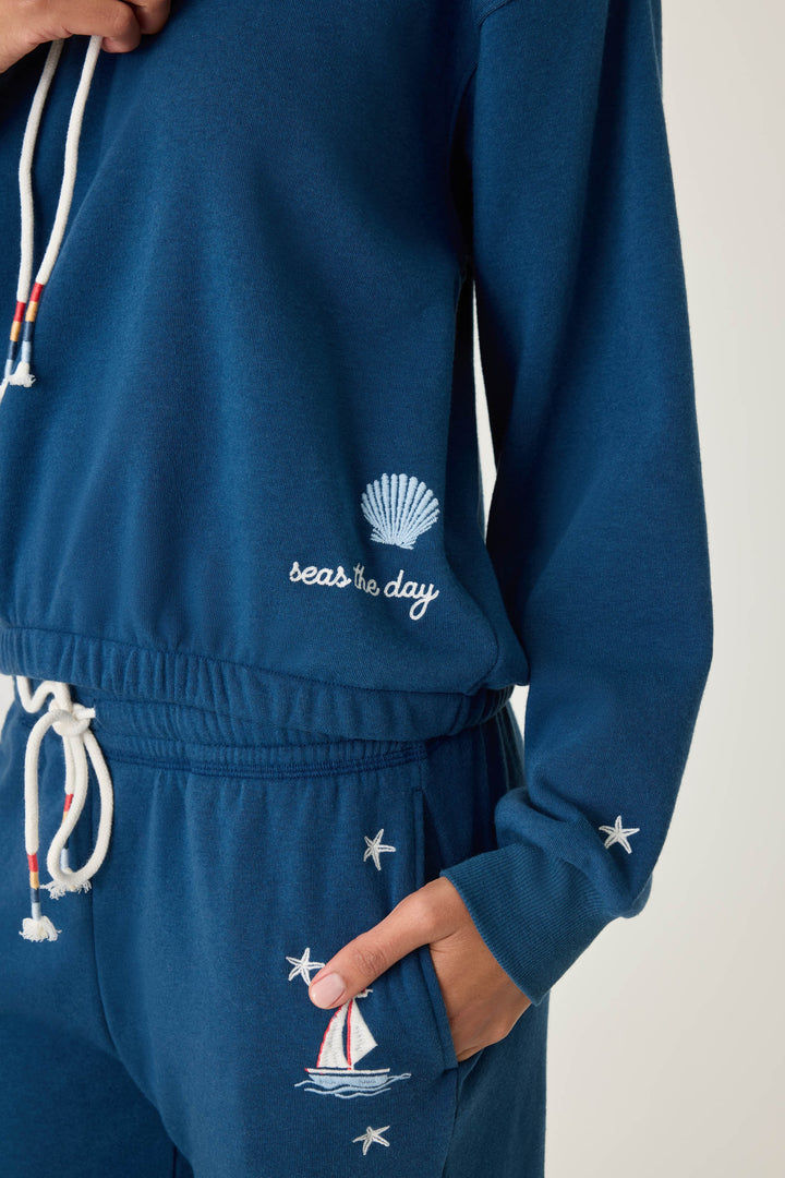 Navy pullover hoody for women in vintage fleece with nautical-inspired embroidery placements (seashell, sun, sailboat, stars)