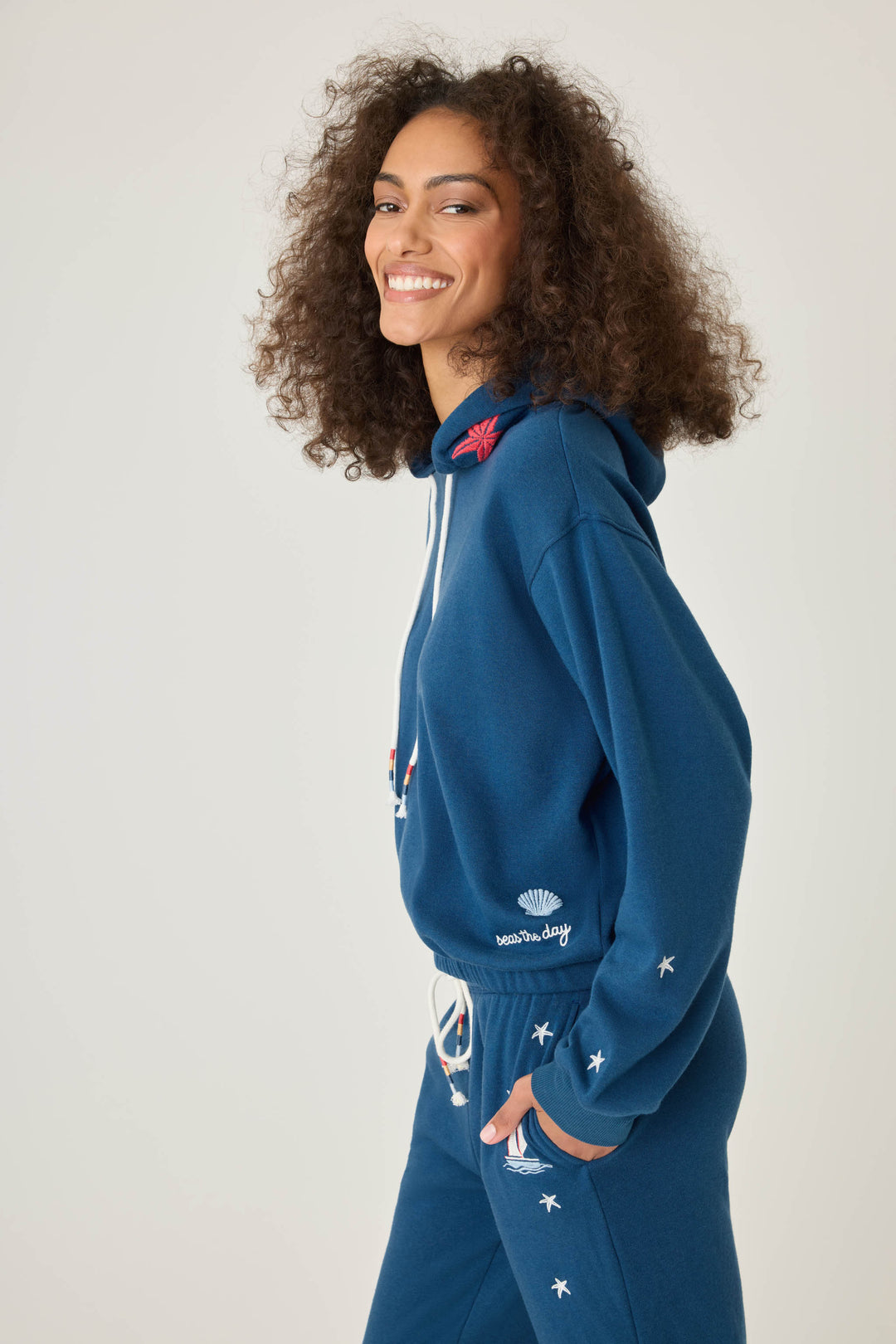 Navy pullover hoody for women in vintage fleece with nautical-inspired embroidery placements (seashell, sun, sailboat, stars)