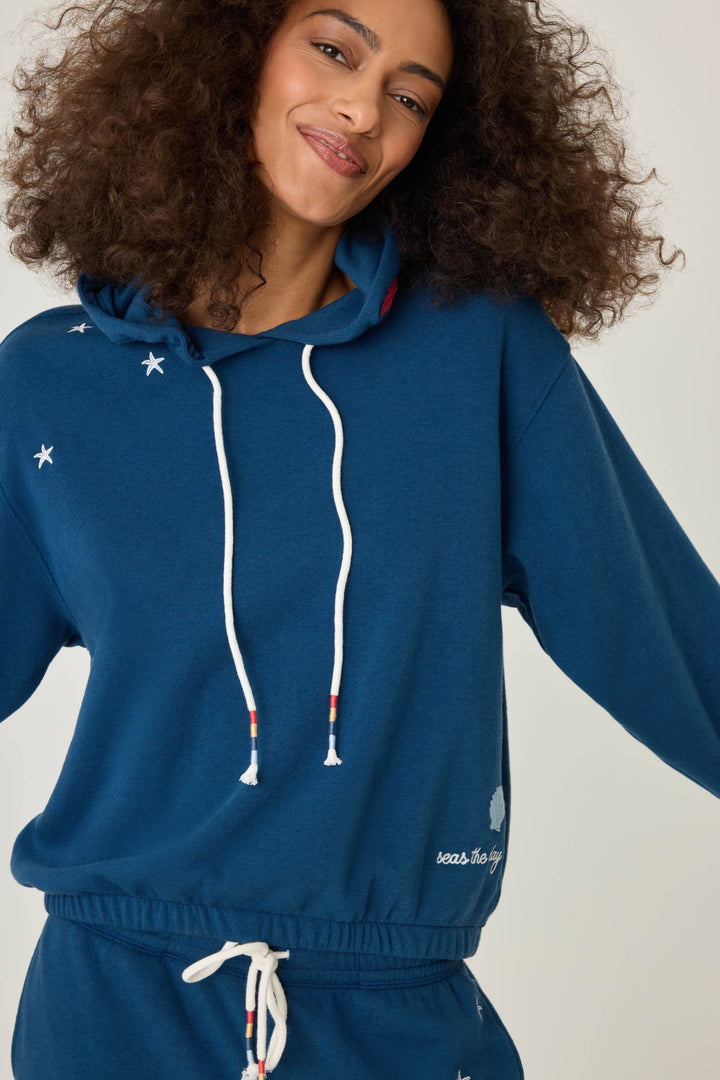 Navy pullover hoody for women in vintage fleece with nautical-inspired embroidery placements (seashell, sun, sailboat, stars)