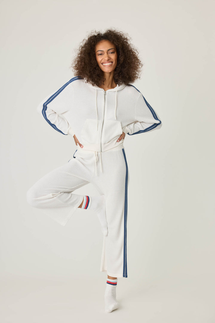 Women's ivory zip hoodie with navy athletic stripes on sleeves. Zip front with two pockets.