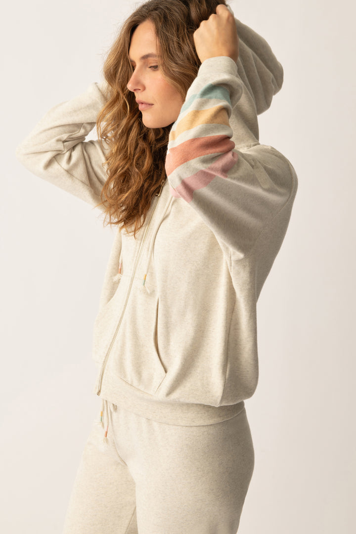 Women's zip hoody in oatmeal with graphic stripe print on sleeve. Lower front pockets.