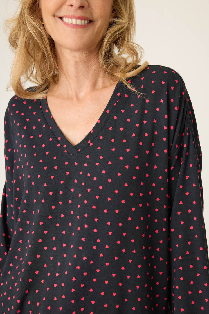 Women's black long sleeve pj top with pink heart pattern.