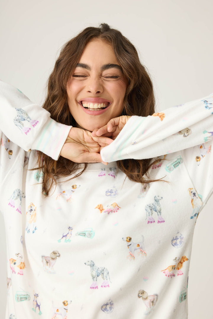 Women's ivory lounge top with dogs on rollerskates pattern. Relaxed fit with banded bottom.