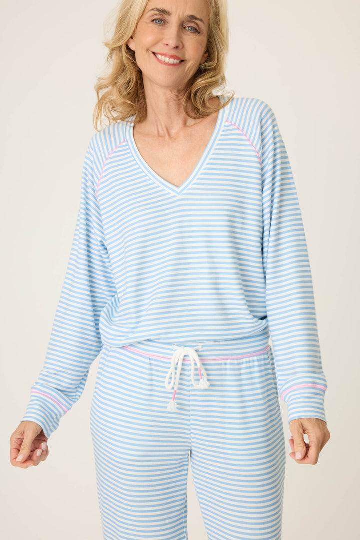 Women's ivory & blue striped V-neck top with bright pink contrast stitching at raglan sleeves. Banded hem.