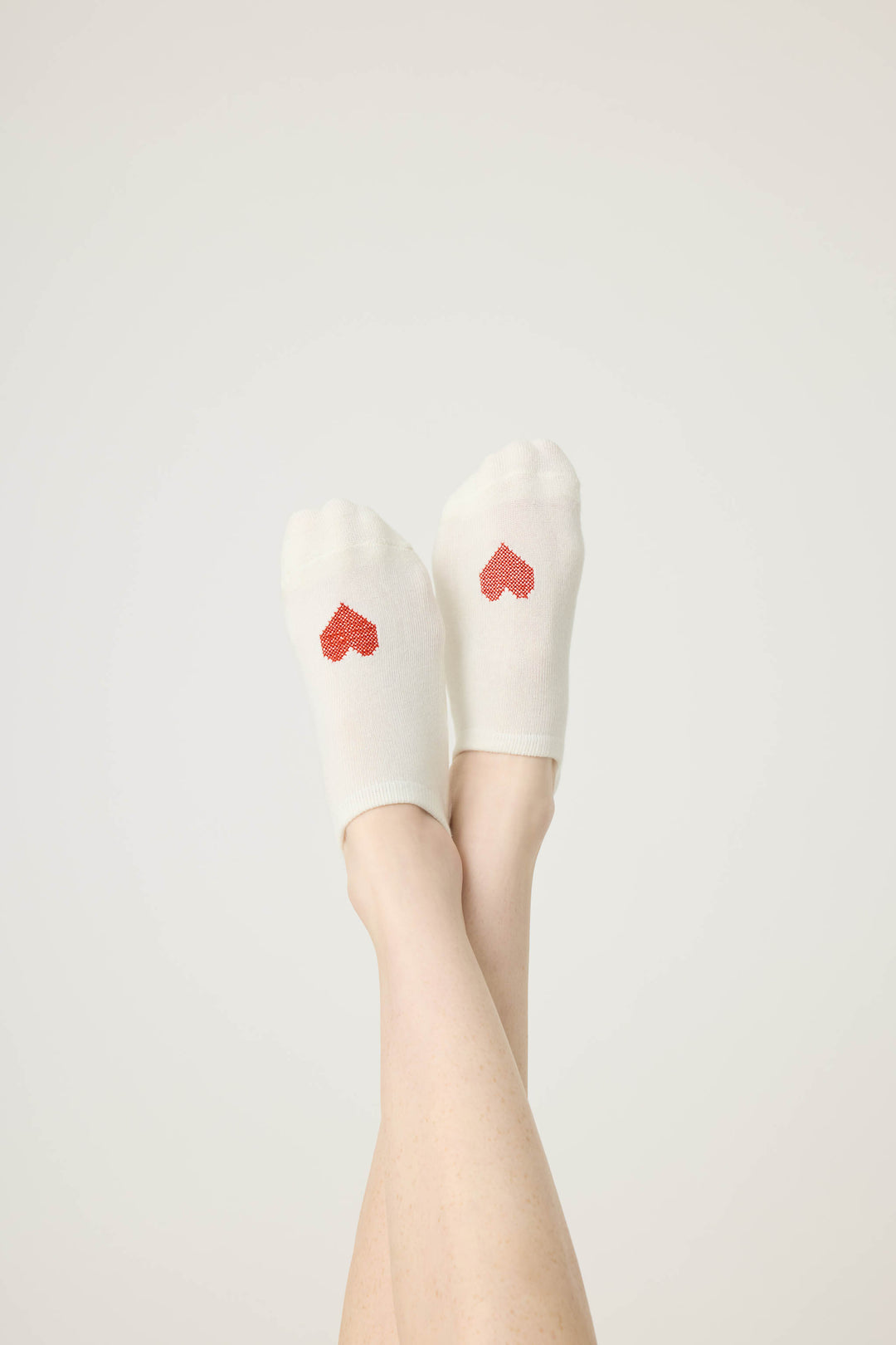 2-pack half-custhion liner socks. Women's & girls' socks in ivory with red heart & solid red, with non-skid grippers on sole.