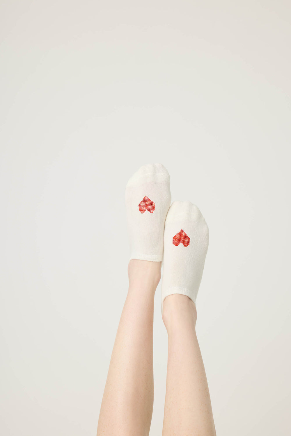 2-pack half-custhion liner socks. Women's & girls' socks in ivory with red heart & solid red, with non-skid grippers on sole.