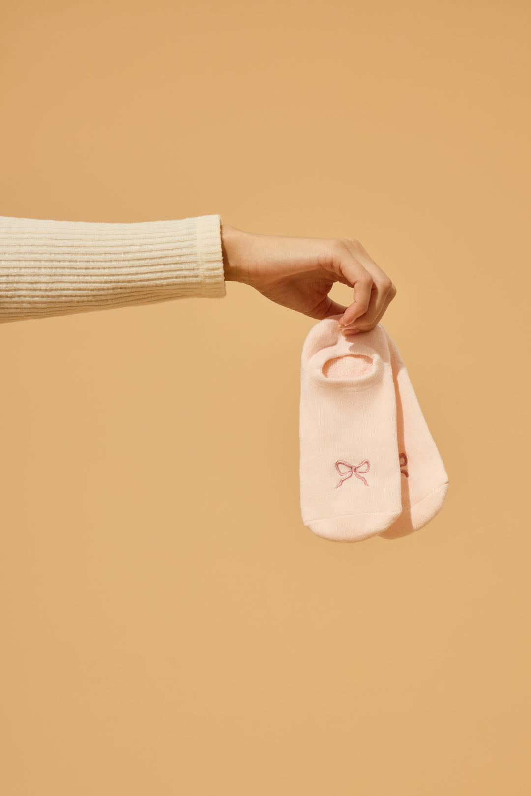 2-pack comfy liners with bow. Women's & girls' pink ped socks with bow detail, with logo non-skid grippers on soles.