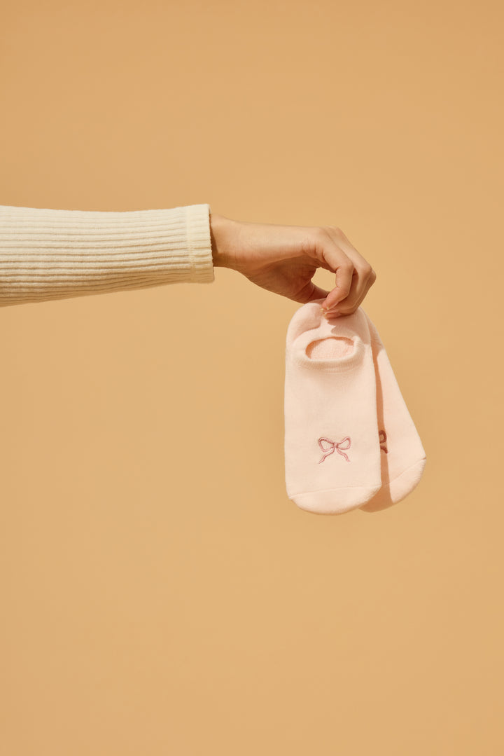 2-pack comfy liners with bow. Women's & girls' pink ped socks with bow detail, with logo non-skid grippers on soles.