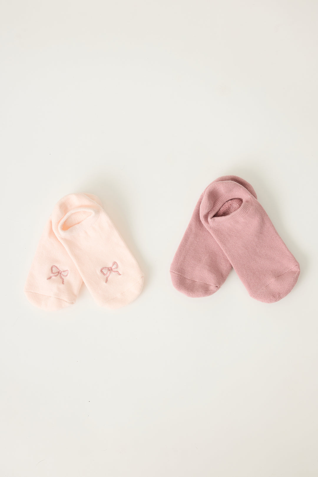 2-pack comfy liners with bow. Women's & girls' pink ped socks with bow detail, with logo non-skid grippers on soles.