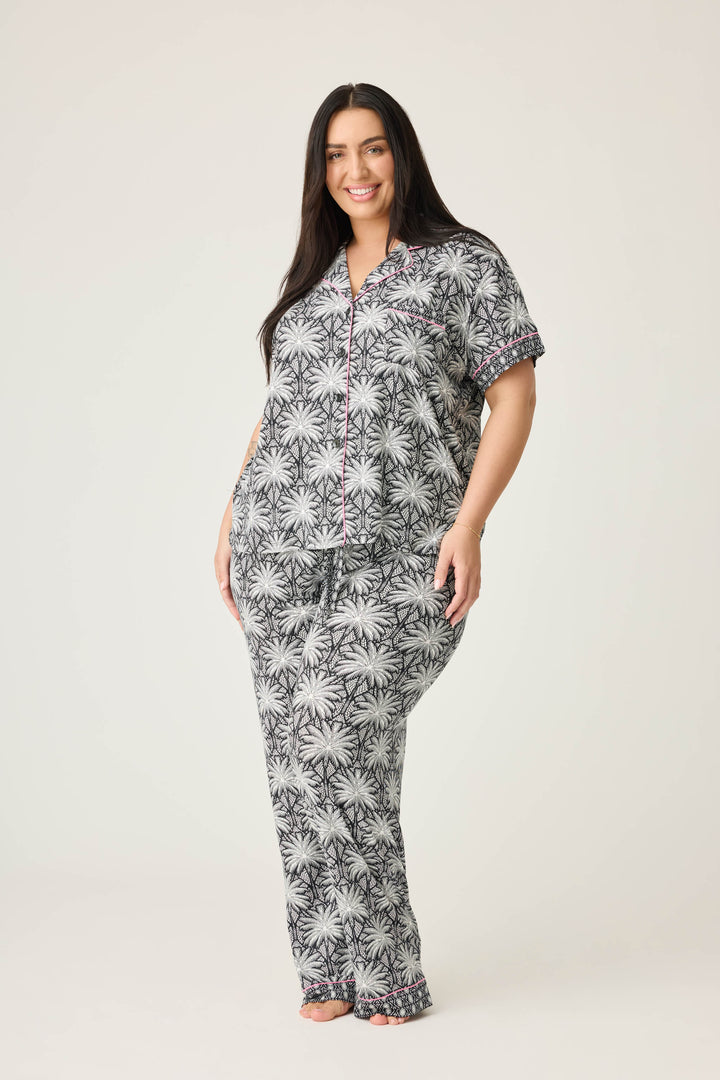 Women's black & ivory palm printed pajama set in modal. Short sleeve button-front top & pajama pant with contrast pink piping.