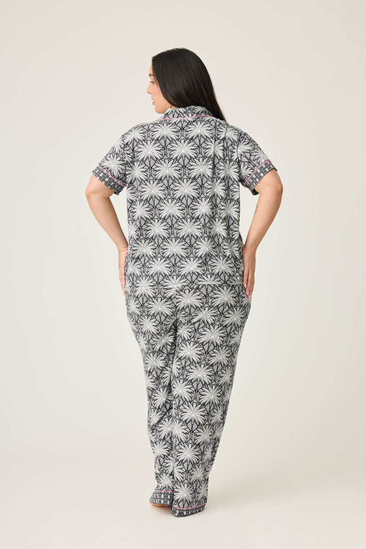 Women's black & ivory palm printed pajama set in modal. Short sleeve button-front top & pajama pant with contrast pink piping.