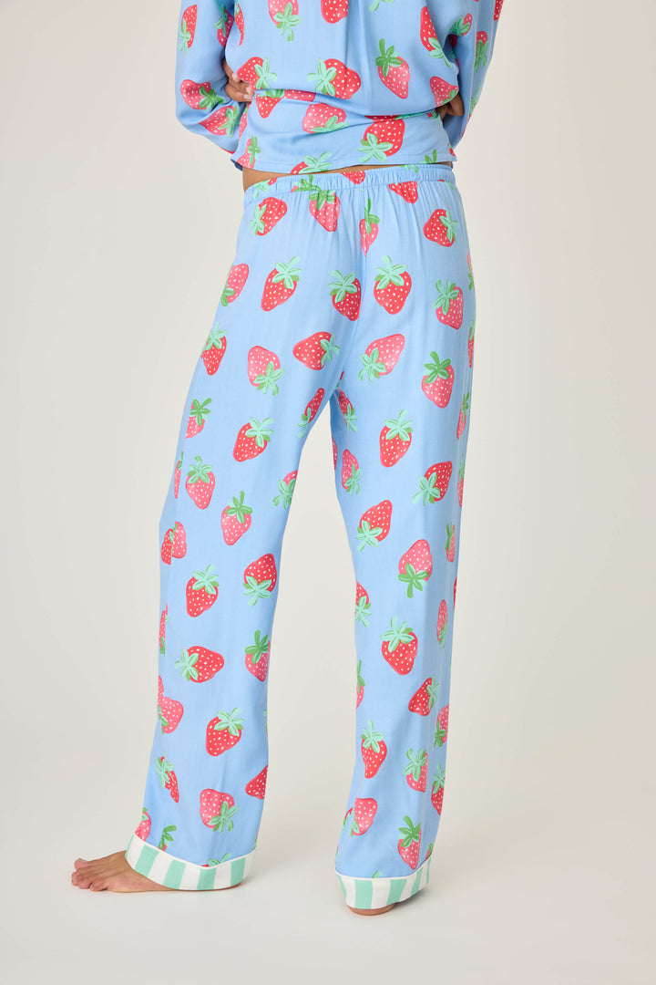 Women's pajama pant in blue with strawberry print in woven rayon sateen. Tie-waist in contrast stripe & striped cuffs.