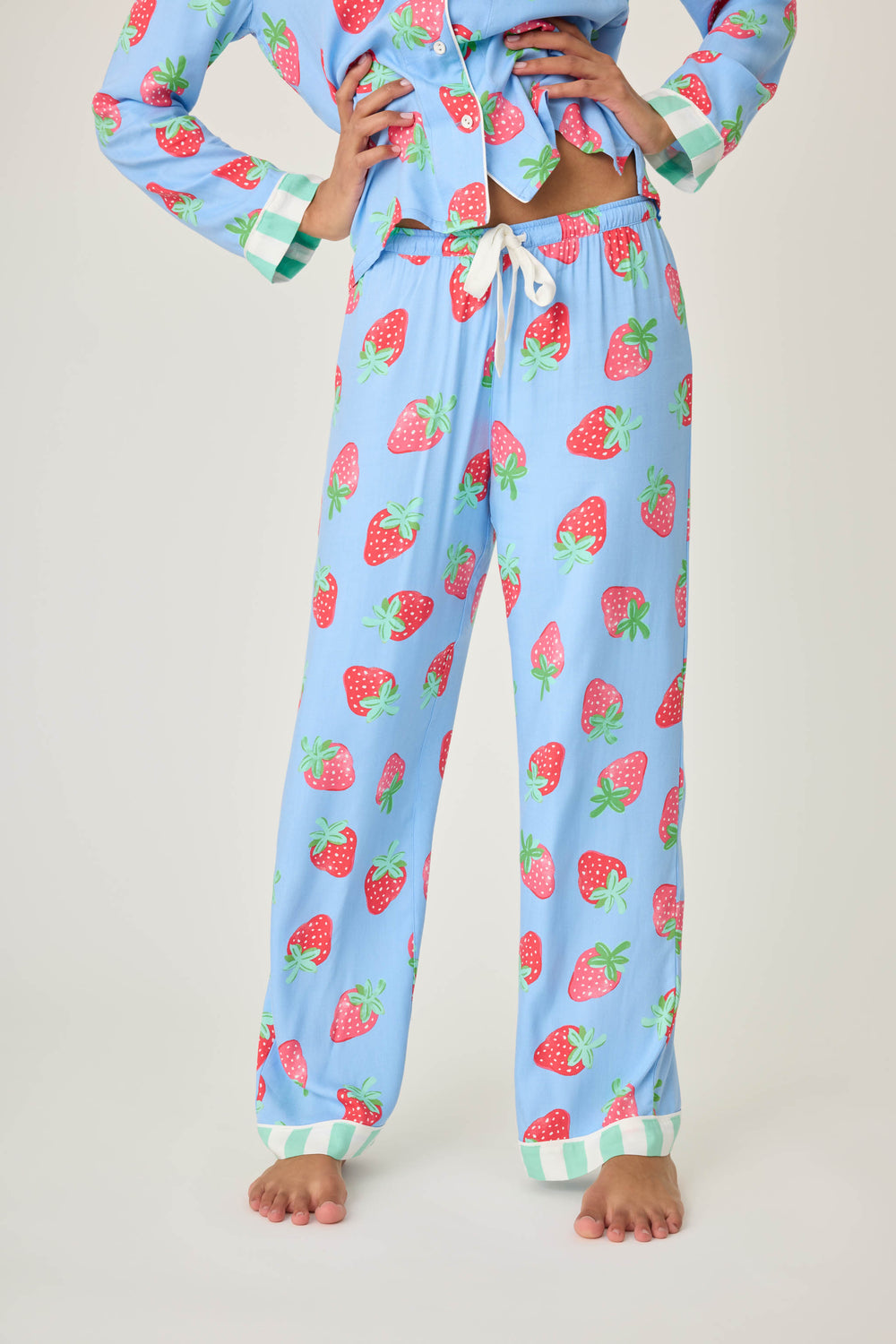 Women's pajama pant in blue with strawberry print in woven rayon sateen. Tie-waist in contrast stripe & striped cuffs.