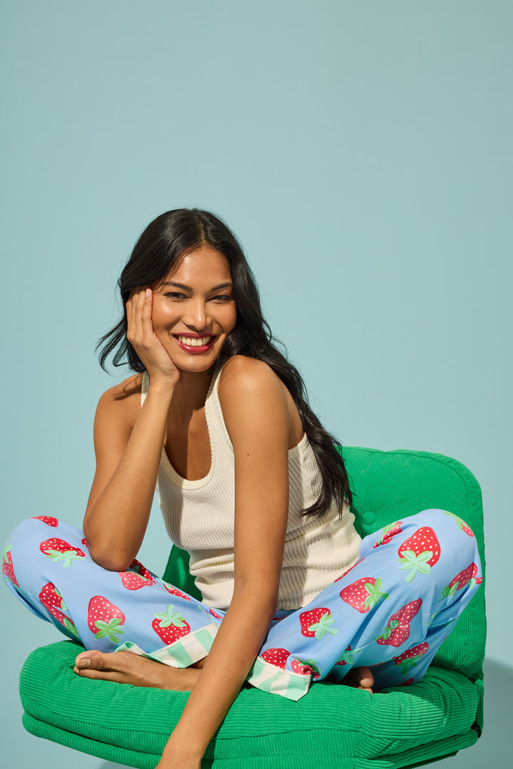 Women's pajama pant in blue with strawberry print in woven rayon sateen. Tie-waist in contrast stripe & striped cuffs.