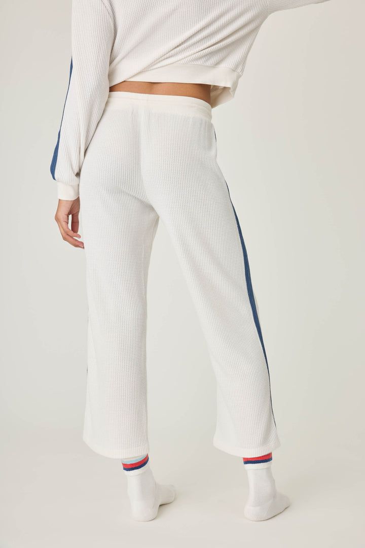 Women's ivory cropped lounge pant with navy athletic stripes on side. Tie waist.