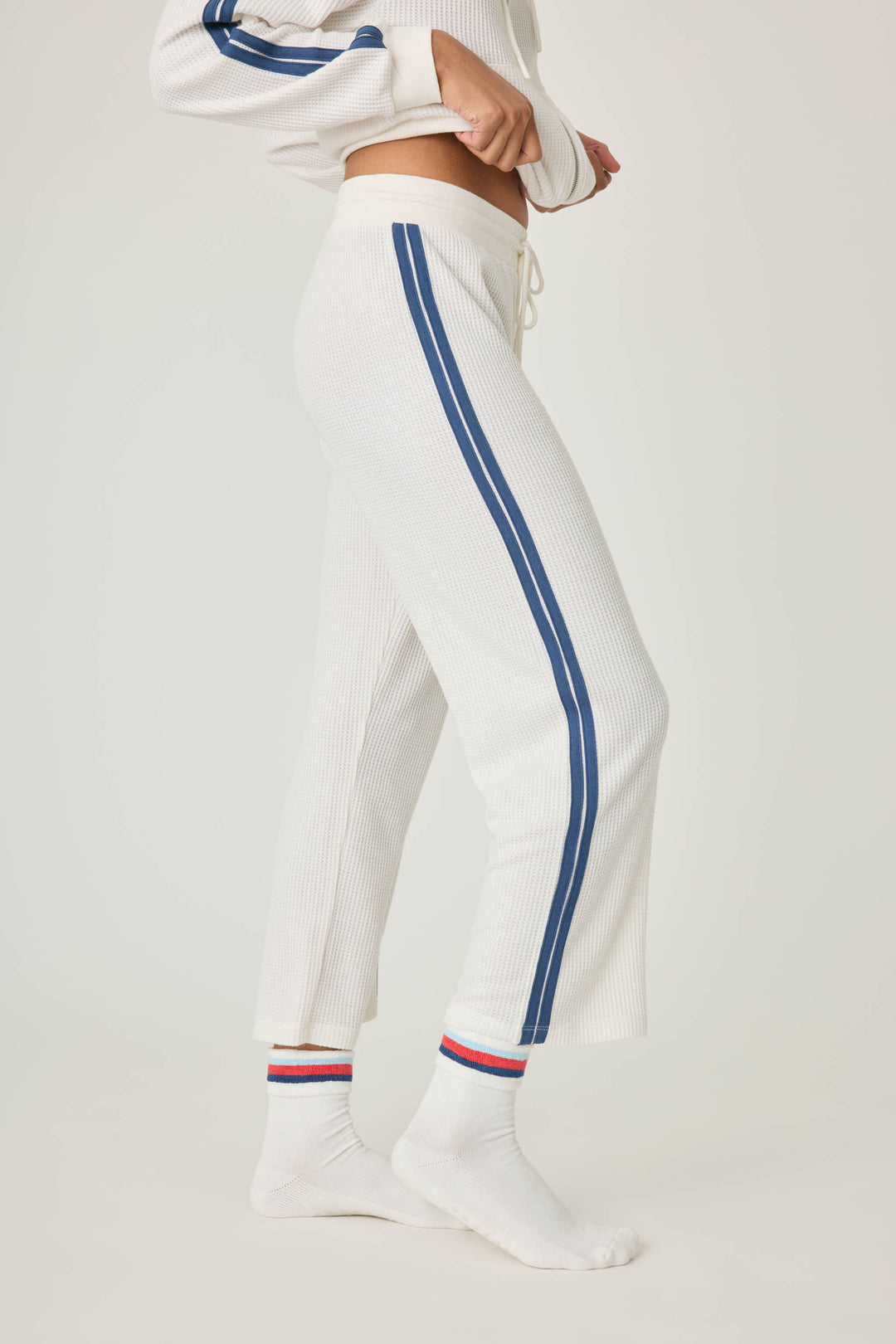 Women's ivory cropped lounge pant with navy athletic stripes on side. Tie waist.