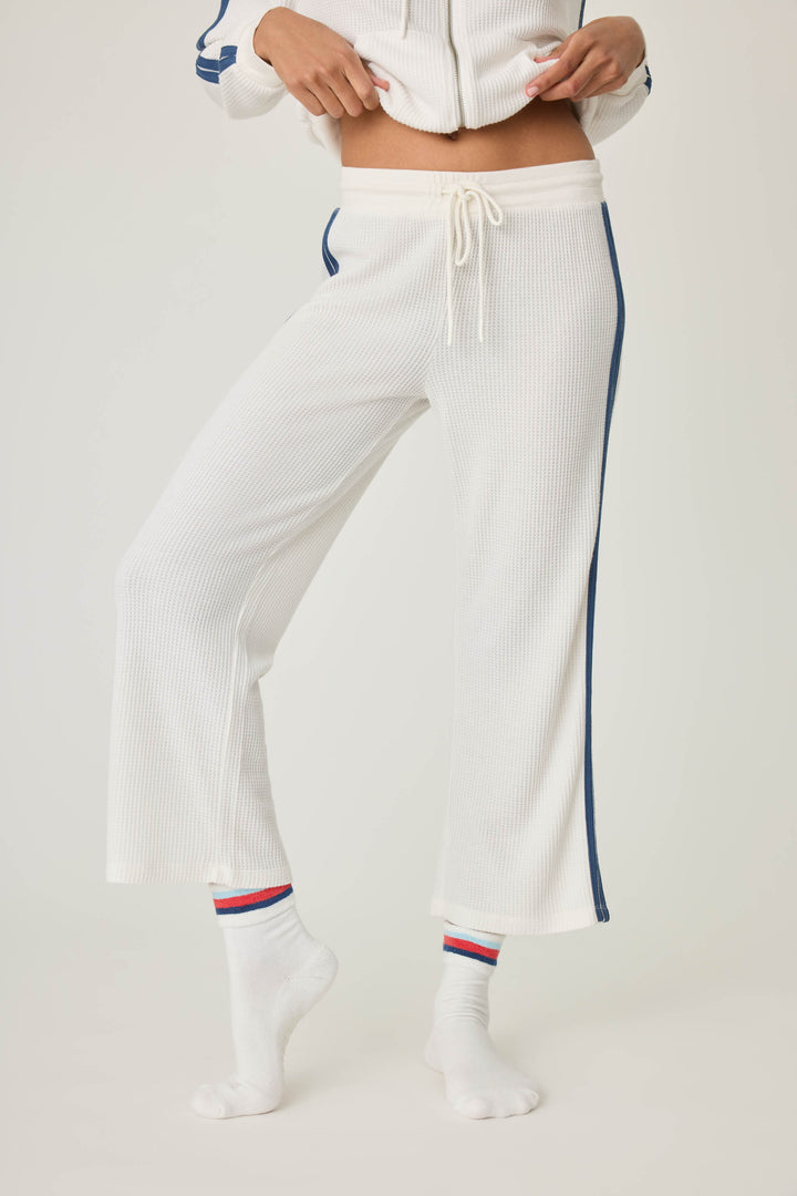 Women's ivory cropped lounge pant with navy athletic stripes on side. Tie waist.
