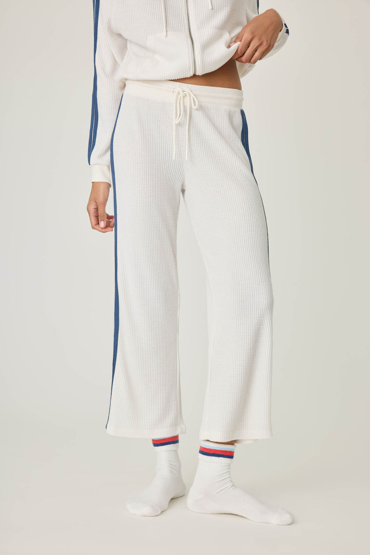 Women's ivory cropped lounge pant with navy athletic stripes on side. Tie waist.
