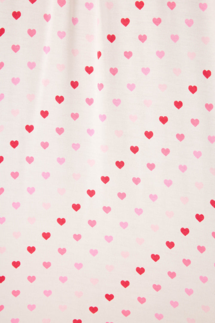 Women's white pj pants with pink heart pattern.