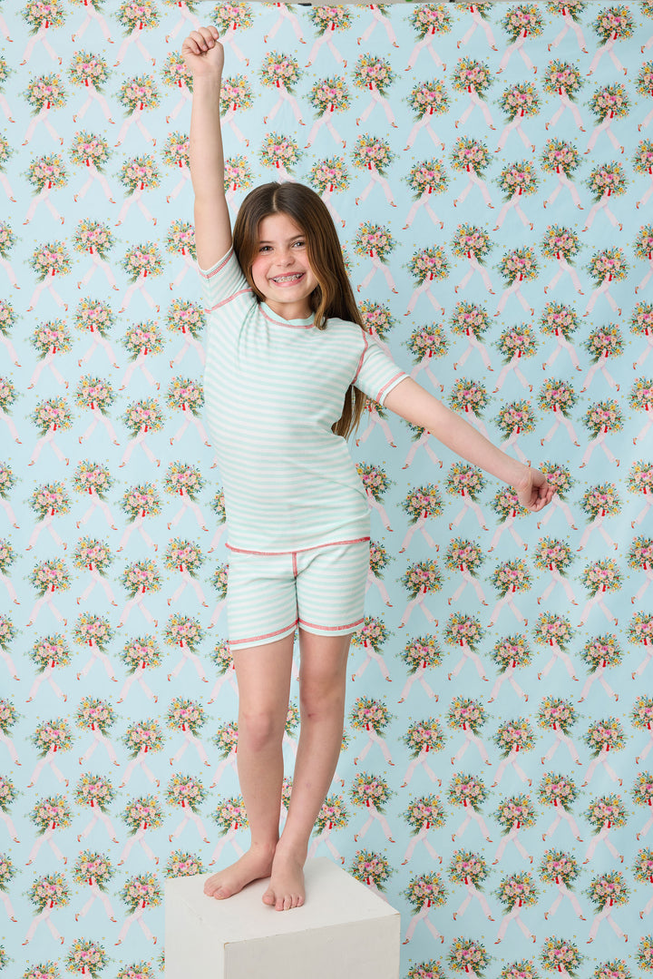 Gender-neutral kids' pajama in mint-ivory stripes with contrast red stitching.