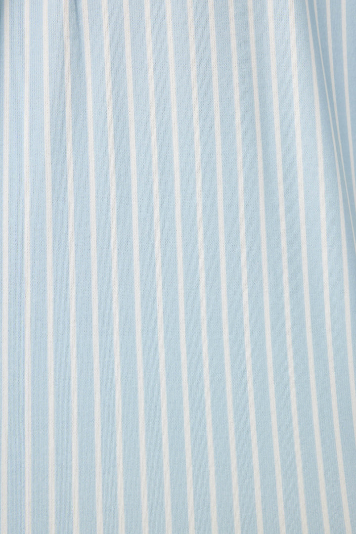 Women's classic pajama set in light blue-white striped butter jersey. Red piping at button-front top & sideseams of pant. Chest pocket with embroidered crab & matching sleep mask with 'Crabby' lettering.
