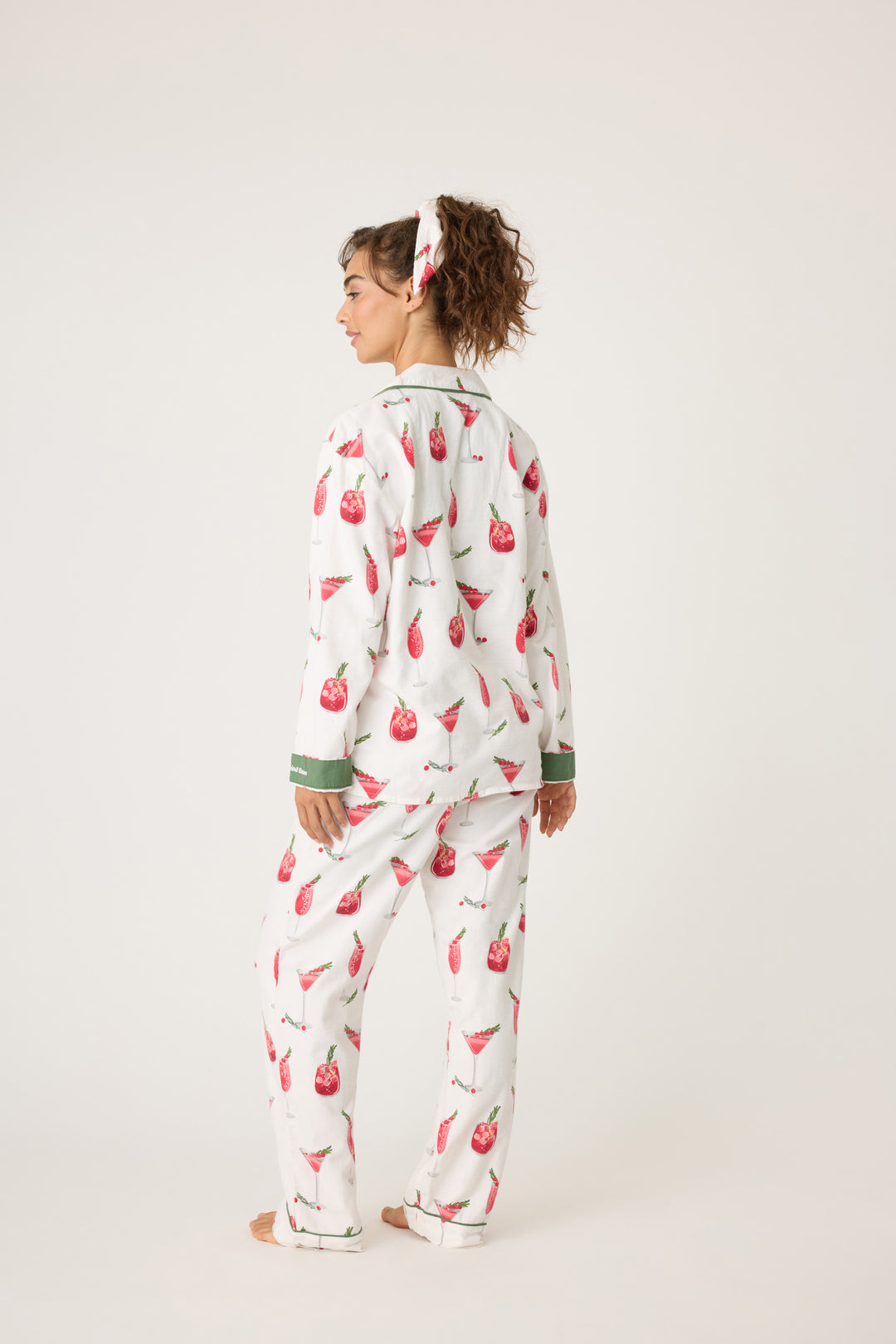 Women's cotton flannel pajama set in ivory & festive red cocktail print. Button-front collared top & tie-waist pant. Embroidered sleeve cuff "Warm Wishes & Cocktail Kisses". Includes matching hair wrap.