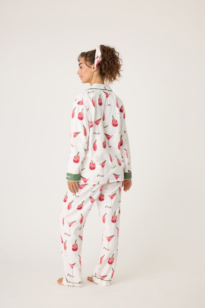 Women's cotton flannel pajama set in ivory & festive red cocktail print. Button-front collared top & tie-waist pant. Embroidered sleeve cuff "Warm Wishes & Cocktail Kisses". Includes matching hair wrap.