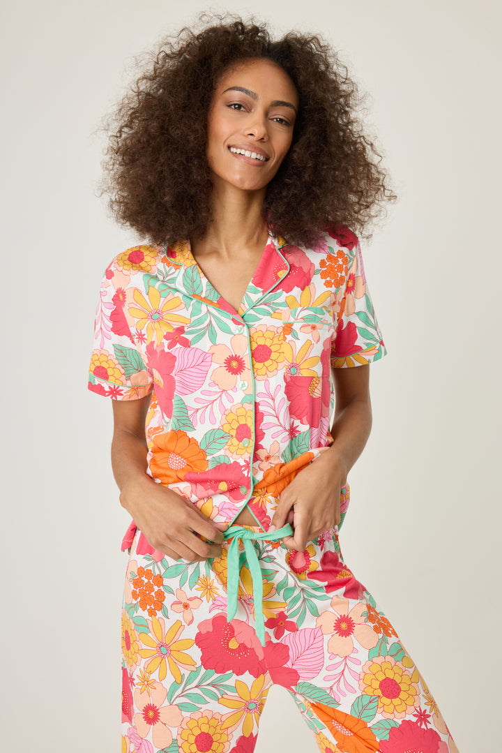 Women's breathable cotton-modal jersey short sleeve pajama set in coral-orange yellow floral print. With aqua contrast piping & tie. Button-front top & open leg pant.