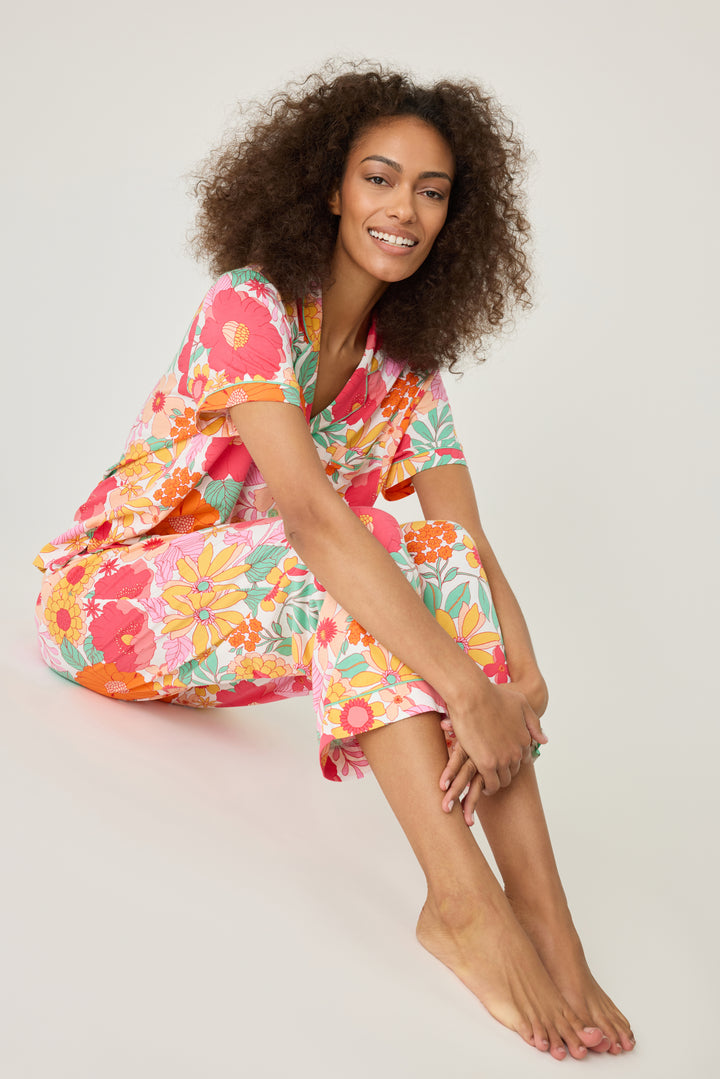 Women's breathable cotton-modal jersey short sleeve pajama set in coral-orange yellow floral print. With aqua contrast piping & tie. Button-front top & open leg pant.