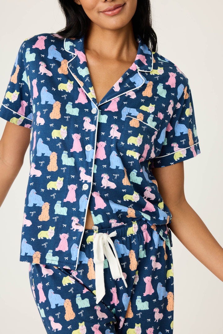 Women's breathable cotton-modal jersey short sleeve pajama set in navy w/pastel dog print with contrast ivory piping. Button-front top & open leg tie-waist pant.
