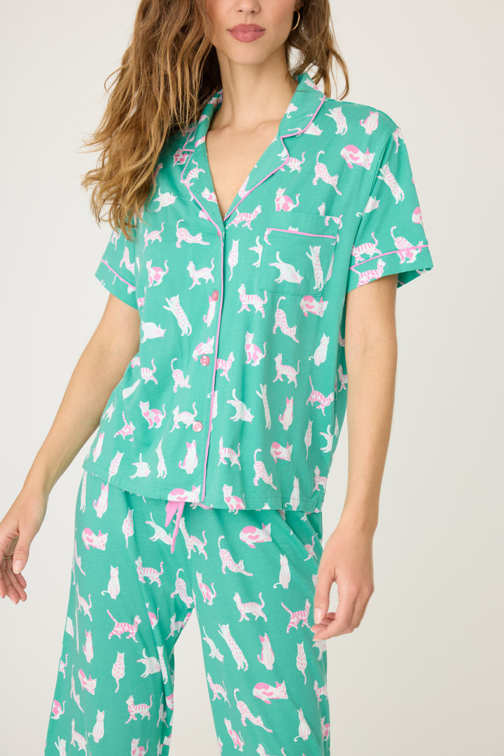 Women's breathable cotton-modal jersey short sleeve pajama set in teal with cats print. With pink contrast piping & tie. Button-front top & open leg pant.