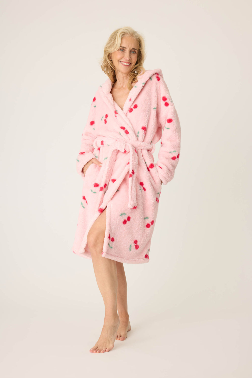 Women's pale pink plush robe with cherry pattern.
