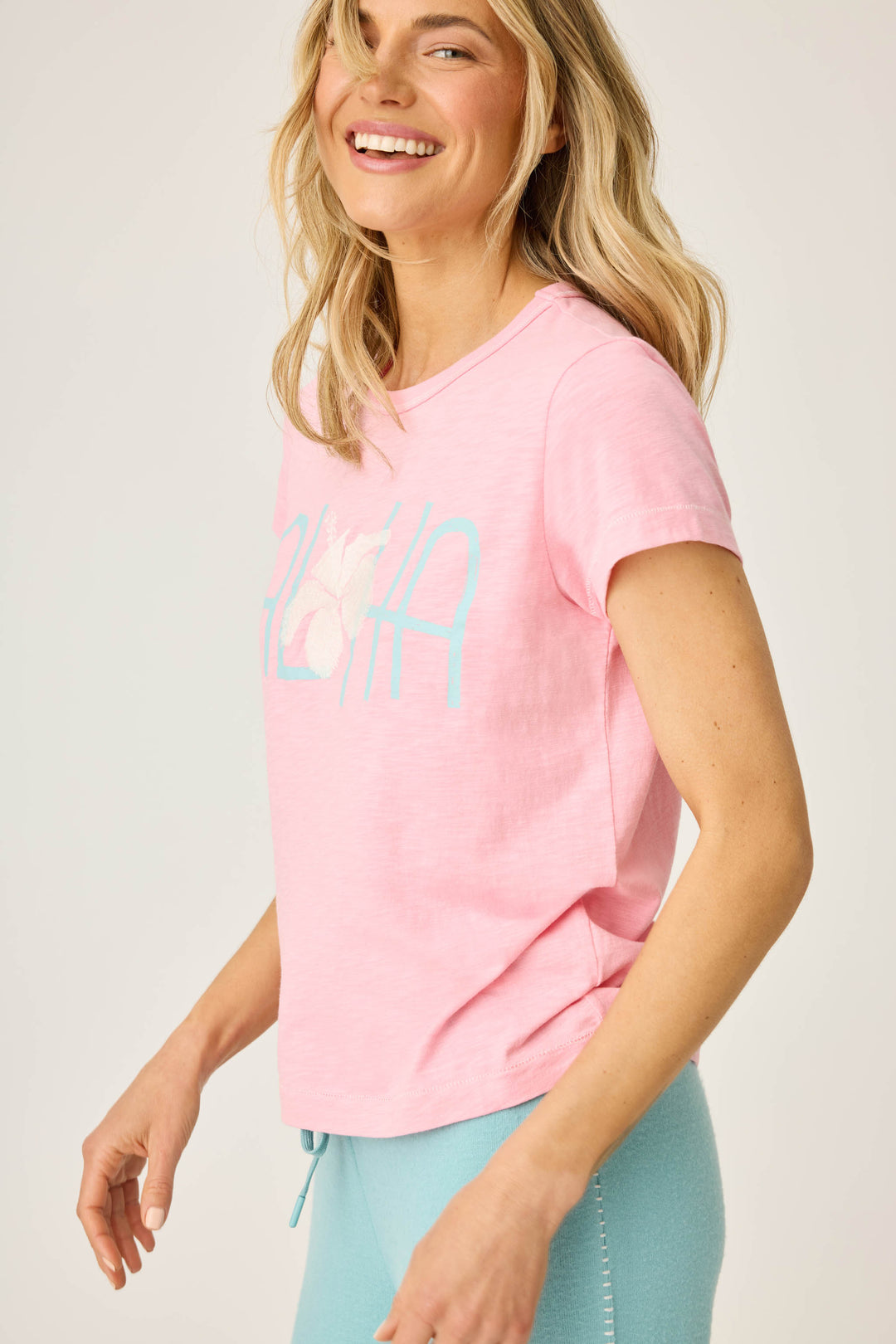 Women's pink short sleeve t-shirt with ALOHA floral graphic print.