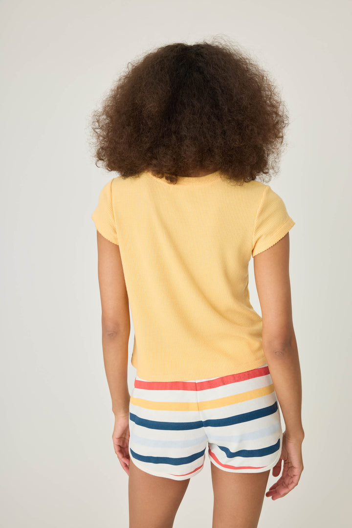 Yellow peachy waffle knit t-shirt with embroidreed shell graphic on front.